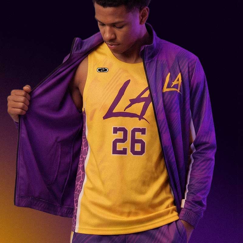 Player opens purple jacket to reveal yellow basketball jersey with number 26